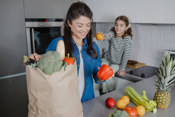 istock Mother and daughter unpacking groceries 1387664951