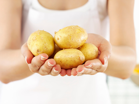 woman holding handful of potatoes