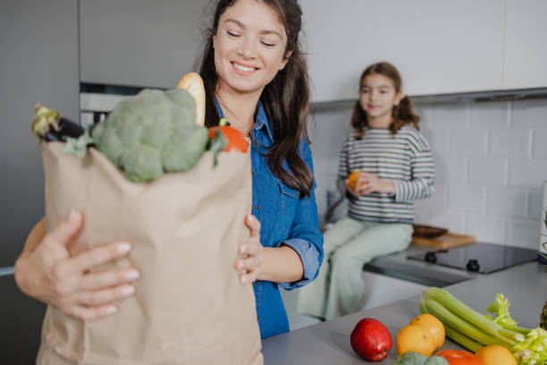 istock Mother and daughter unpacking groceries 1387665156