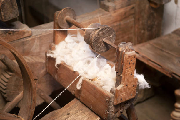 Vintage traditional spinning wheel, distaff with yarn in wooden home interior. Shallow Depth of Field. SDF.