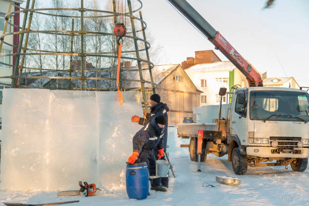istock Two installers cover the metal frame with ice blocks 1387667796