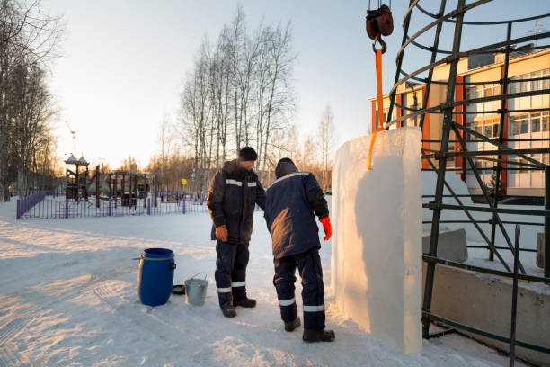 istock Two installers cover the metal frame with ice blocks 1387667856