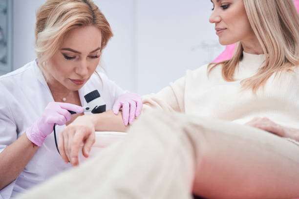istock Concentrated dermatologist examining her client skin with dermoscope 1387668916