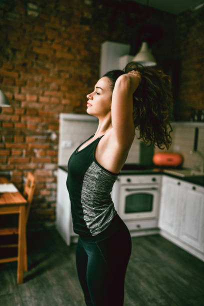 istock Beautiful Athletic Female Tying Hair Before Starting Home Workout 1387669617