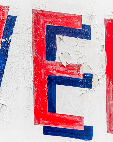 Close up of a red and blue letter E on a white background.