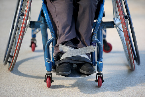 Close-up on wheelchair straps on feet for support.
