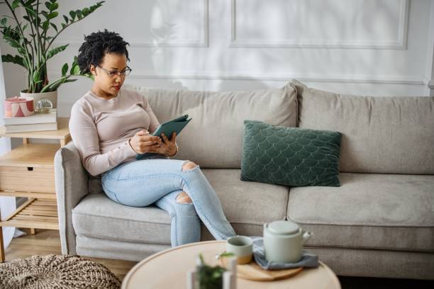 istock Woman relaxing on the couch and using digital tablet 1387676255