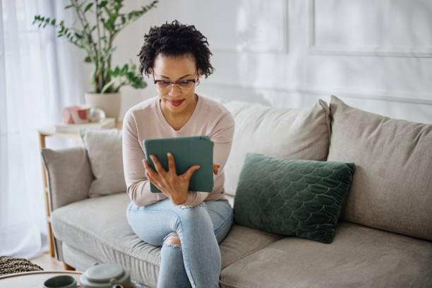 istock Woman relaxing on the couch and using digital tablet 1387676299