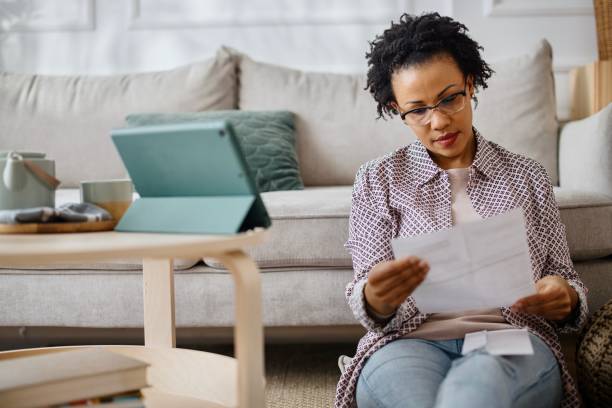 istock Woman at home paying bills online 1387676488