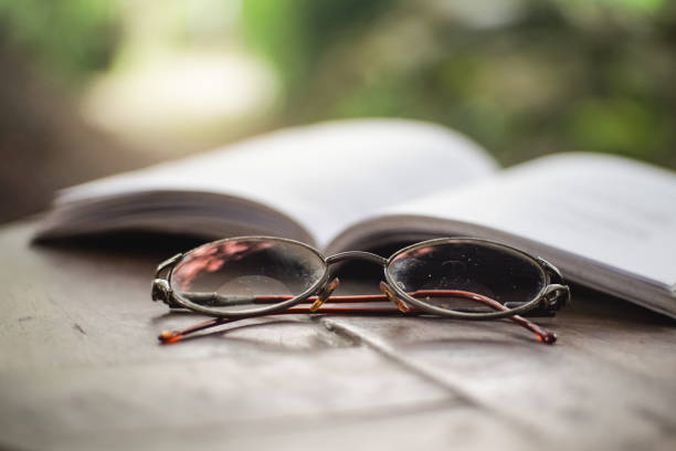 Glasses lying near book on wooden table