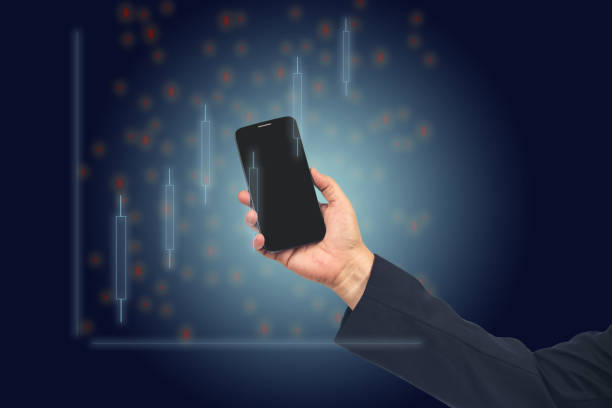 istock Hand holding smartphone looking at Stock exchange trading data information displayed symbol. Investor and trader concept. 1387679568