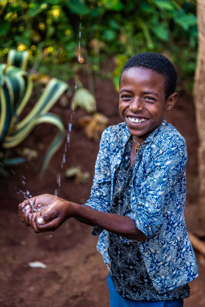 istock African young boy drinking fresh water, East Africa 1387679608