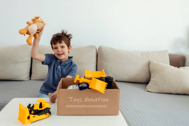 istock Boy preparing his toys for donations for kids. 1387679665