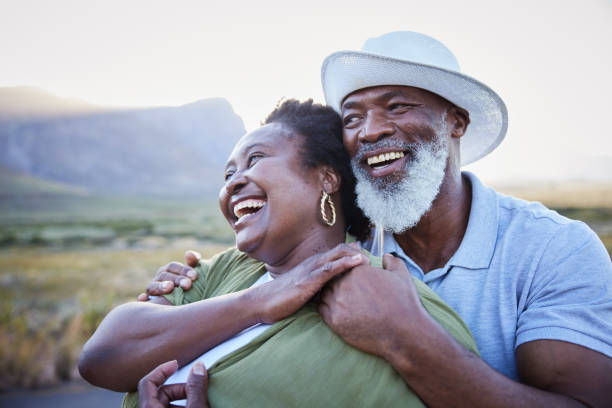 hombre maduro abrazando a su esposa risueña mientras disfruta de un día al aire libre - wife expressing positivity content loving fotografías e imágenes de stock