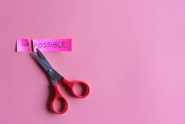 istock Cutting the word impossible to possible on pink background 1387682778