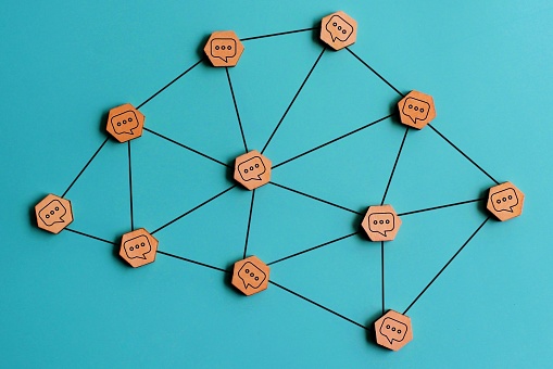 Online communication or social networking concept. Wooden cubes with speech bubble connected with lines.