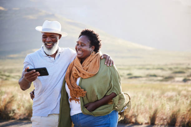 istock Mature couple smiling and taking selfies during a day outdoors in nature 1387685404