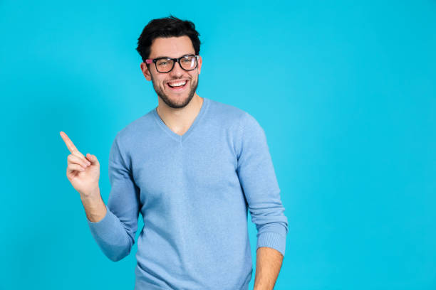 istock Smiling Laughing Positive Confident Caucasian Handsome Brunet Man While Looking Straight To Side Against Blue Background. 1387686369