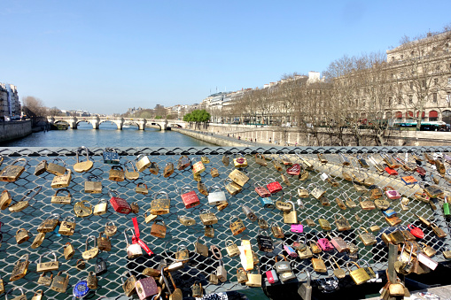 Love padlocks at the Pont des Arts bridge and the Seine River facing the Pont Neuf in Paris, France