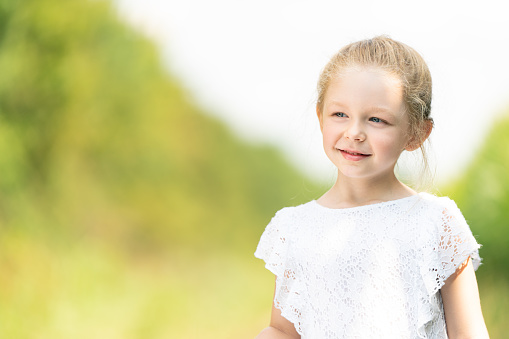 portrait of a smiling little girl in a field