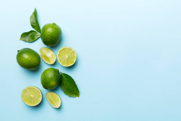 istock Lime fruits with green leaf and cut in half slice isolated on white background. Top view. Flat lay with copy space 1387690663