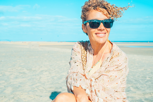 Summer portrait of cheerful happy adult young woman with sunglasses admiring the beach. Holiday vacation lifestyle with pretty female people tourist enjoying and relaxing in leisure outdoor