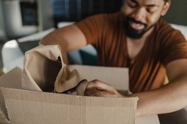 istock Close up of a young man unpacking online purchase 1387696347