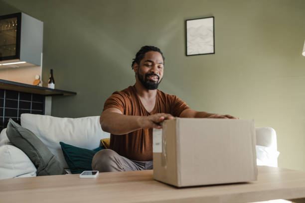 istock Young man is ready to open a delivery package 1387697159