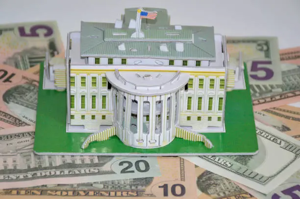 Photo of model of the White House of the President on the background of dollars