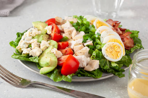 healthy American Cobb salad with egg bacon avocado chicken tomato. hearty keto low carb diet stock photo