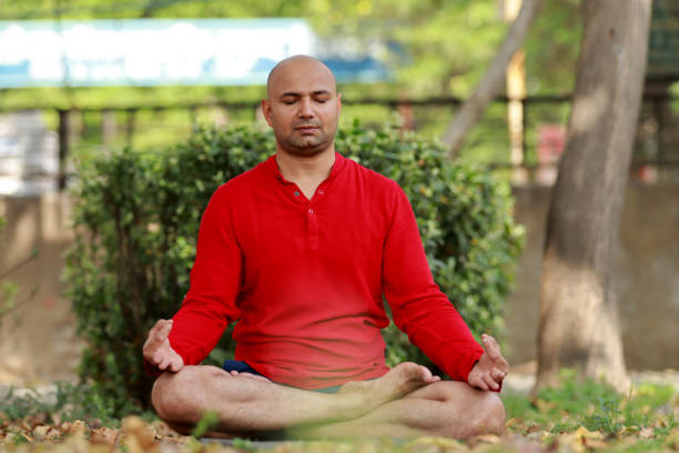 istock Bald meditating in the park 1387700375