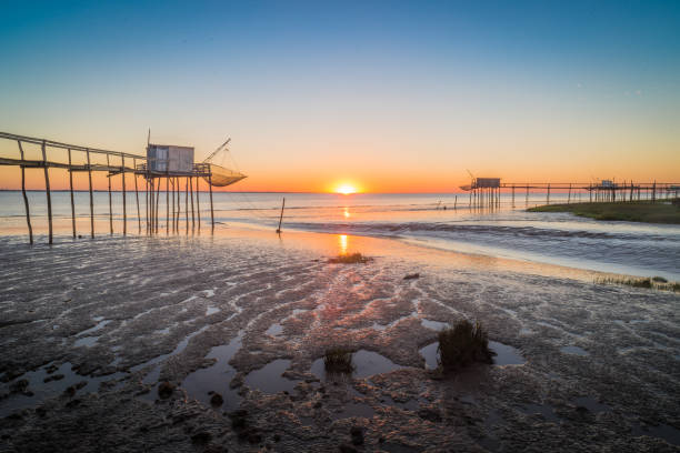 Fishing huts on Atlantic coastline at sunset near la Rochelle