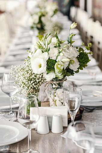 Wedding table decoration with flowers and ribbons.