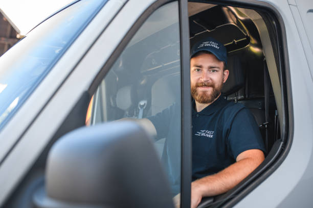 istock Young Delivery Man Sitting In Van Cockpit 1387713931