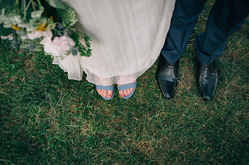 A couple's wedding shoes seen on grass, from above