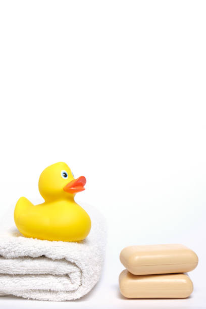 istock Yellow rubber duckling on white terry towel and two pieces soap. 1387718551
