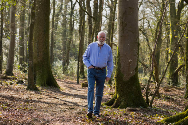 istock Elderly man walking in the woods 1387718813
