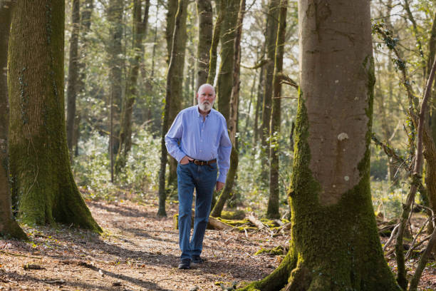 istock Elderly man walking in the woods 1387718845