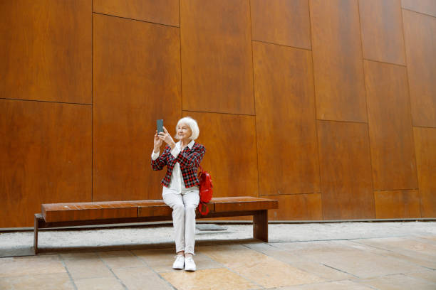 istock Pensive pensioner female resting on city bench 1387719817