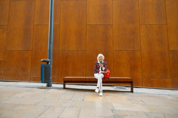 Good looking senior lady resting at city center