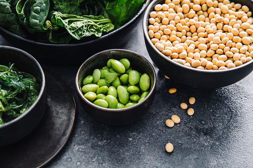 Different types of legumes in bowls, yellow and green peas, mung beans and chickpeas , colored beans and lentils, top view, copy space
