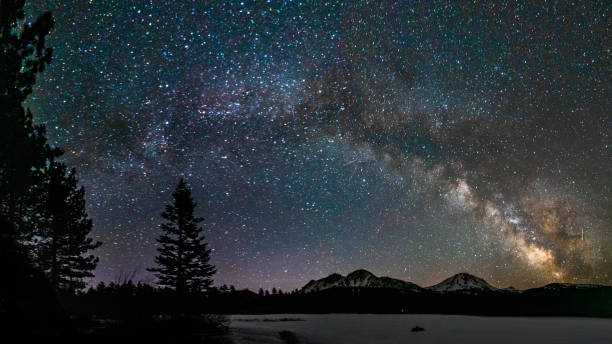 the milky way arching over frozen lake manzanita - mt lassen imagens e fotografias de stock