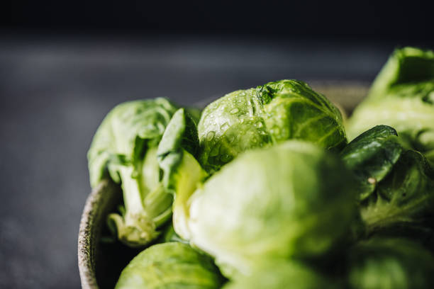 Close-up of raw brussels sprouts in a bowl. Group of whole fresh green brussels sprouts in bowl.