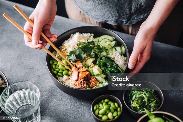 Woman Eating Poke Salad With Chopsticks Stock Photo - Download Image Now - Protein, Women, Eating