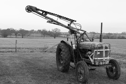 An old antique hedge trimmer mounted on a vintage tractor
