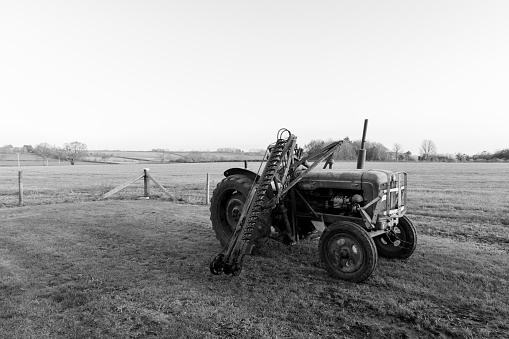 An old antique hedge trimmer mounted on a vintage tractor