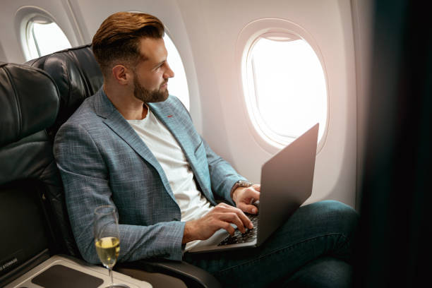 istock Male passenger working on laptop in airplane 1387722690