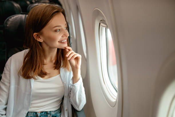 istock Joyful woman looking out the window in airplane 1387722714