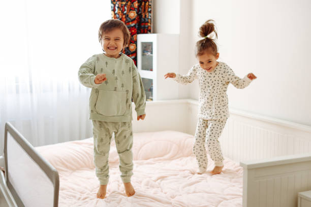 istock Happy funny child  jumping on bed alone feeling joy 1387729382