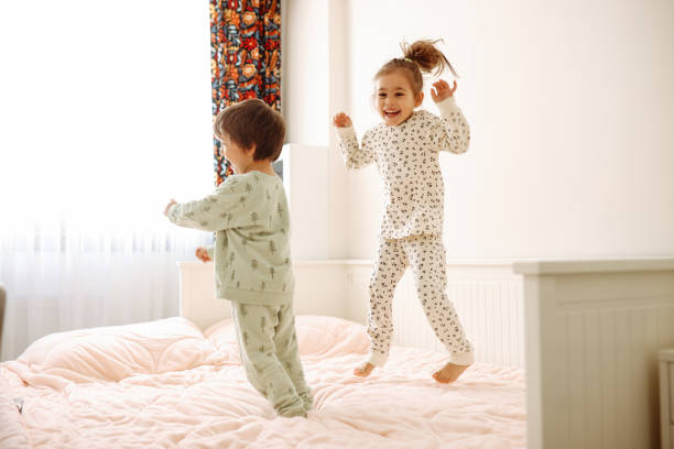istock Happy funny child  jumping on bed alone feeling joy 1387729412